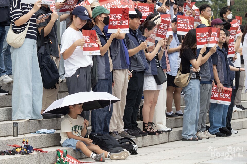 10일 오후 서울 영등포구 국회 본청 앞 계단에서 열린 ‘노후파탄, 분열조장 윤 정부 연금개악안 규탄한다! 기자회견’에 아이와 함께 참가한 부모가 ‘자동삭감 No! 보험료 차등 인상’이라는 문구가 적힌 손피켓을 들고 아이를 바라보고 미소짓고 있다. ⓒ 참여와혁신 천재율 기자 jycheon@laborplus.co.kr